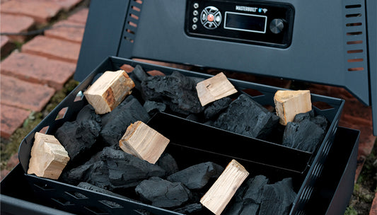 Wood chunks placed on top of chunk charcoal in a smoker charcoal tray