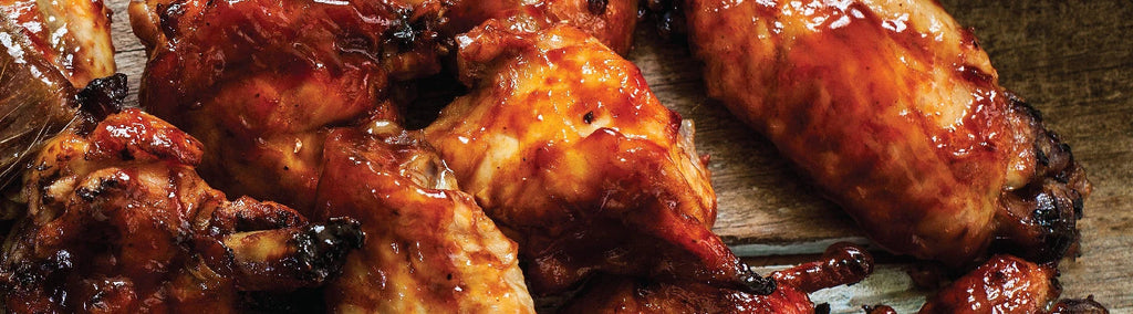 A pile of grilled and sauced chicken wings