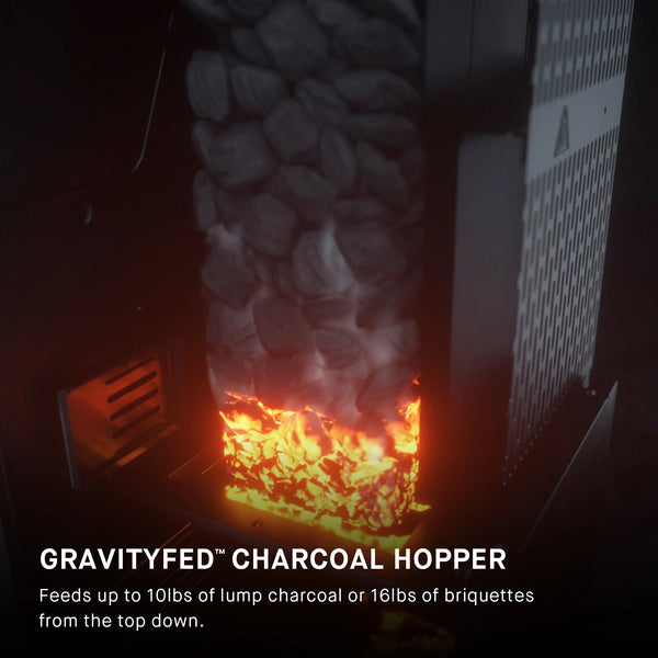 Cutaway view of the GravityFed charcoal hopper with glowing coals at the bottom. Overlay text reads: GravityFed Charcoal Hopper feeds up to 10 lbs of lump charcoal or 16 lbs of briquettes from the top down.