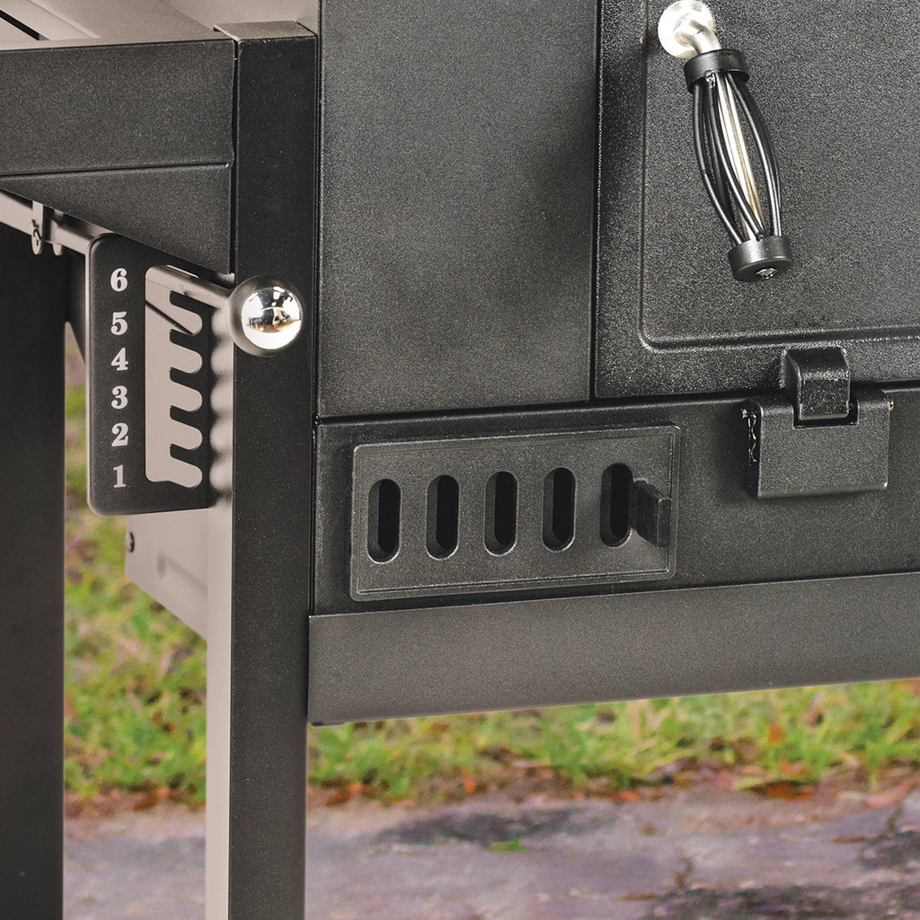 Closeup of the 6-setting grill grate adjustment control knob on the left side of the grill body. The left adjustable air flow vent and the left handle of the charcoal access door are also visible.