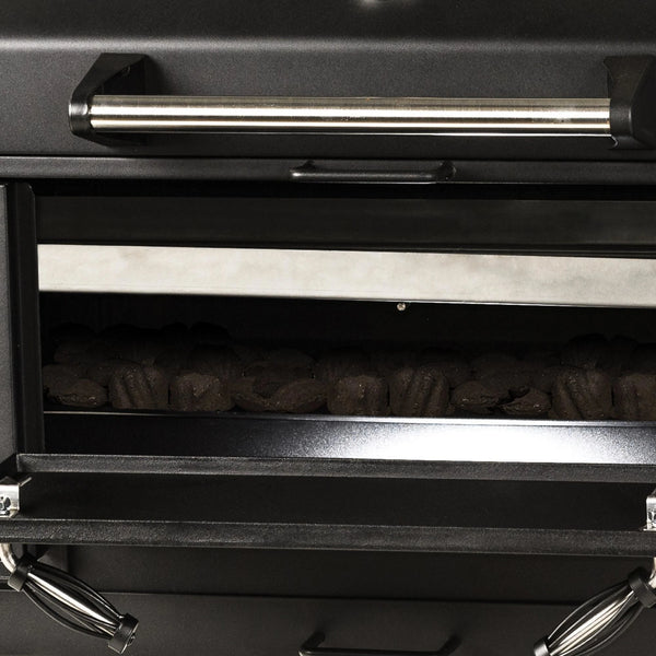 Closeup of the charcoal area with the front access door open. A bed of unlet charcoal can be seen inside the grill body.