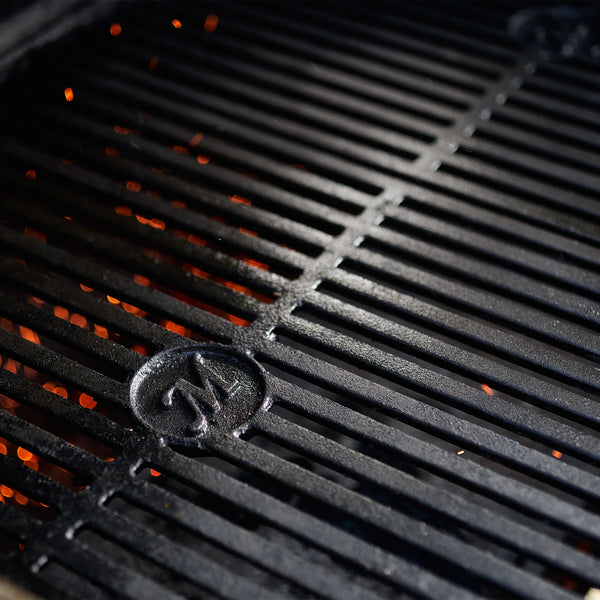 Reversible cast iron grates on a grill with visible Masterbuilt logo. 