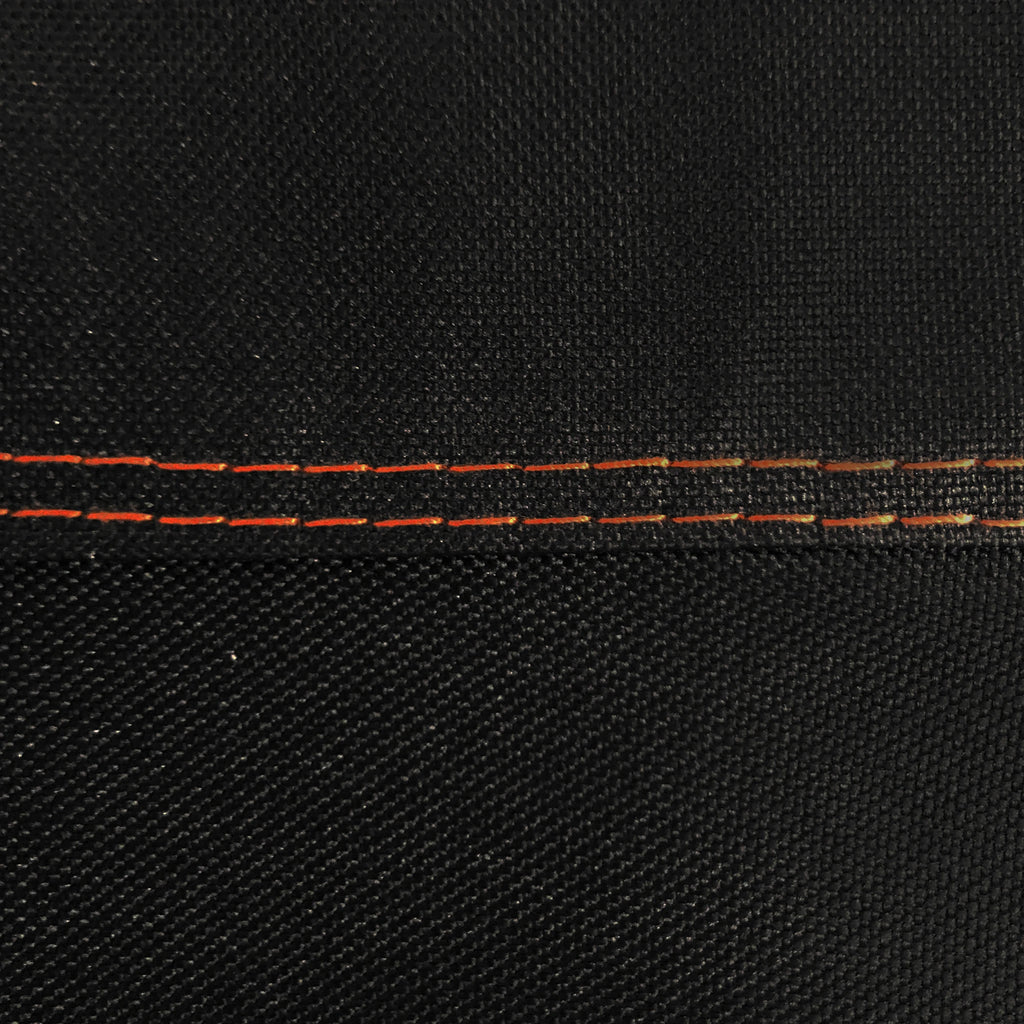 Closeup of the double-stitching on the cover. The stitching is done in orange to make a visual highlight against the black cover.