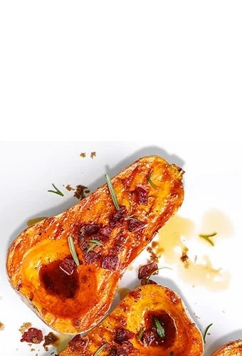 Grilled butternut squash halves topped with fresh rosemary, candied bacon, and a glaze that's puddling in the hollows where where the seeds were.