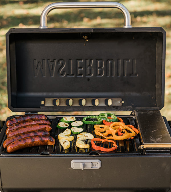 Sausages and vegetables on an open Portable Charcoal Grill